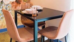 A dining table with four chairs, a glass of whiskey, and a floral wall mural. - Comfortable Studio with Great City Access (Sheffield)
