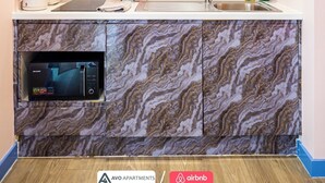 A kitchen with a built-in microwave, a sink, and a marble backsplash. - Comfortable Studio with Great City Access (Sheffield)