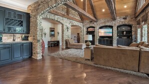 A spacious living area with stone walls, wooden beams, and a fireplace. - Experience the charm of Kentucky with cosy stay! (Nicholasville)