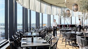 A modern restaurant with high ceilings, large windows, and a view of the city. - The Jitterbug - Sleeping 4 Guests (The Hill)