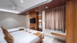 A modern hotel room with two beds, a TV, and a window with curtains. - THE PARADISE PLATINUM (Kanchipuram)