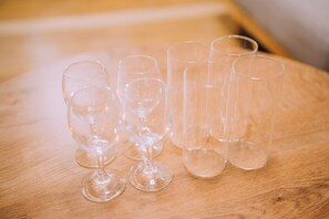 A wooden table with several clear wine glasses arranged on it. - Showa Bloom · Near Shinjuku Station (Tokyo)