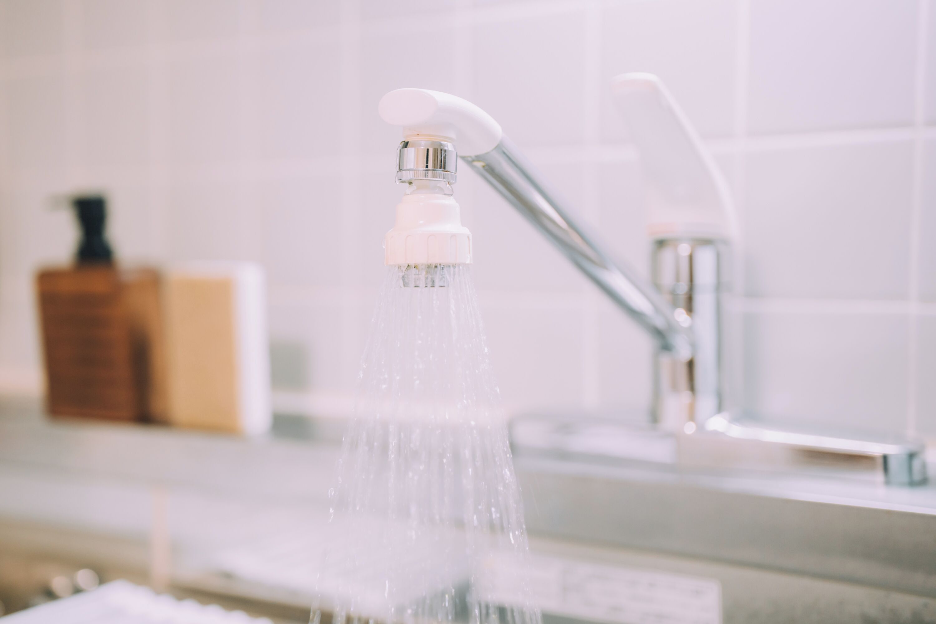 A bathroom with a modern faucet and a visible soap dispenser.