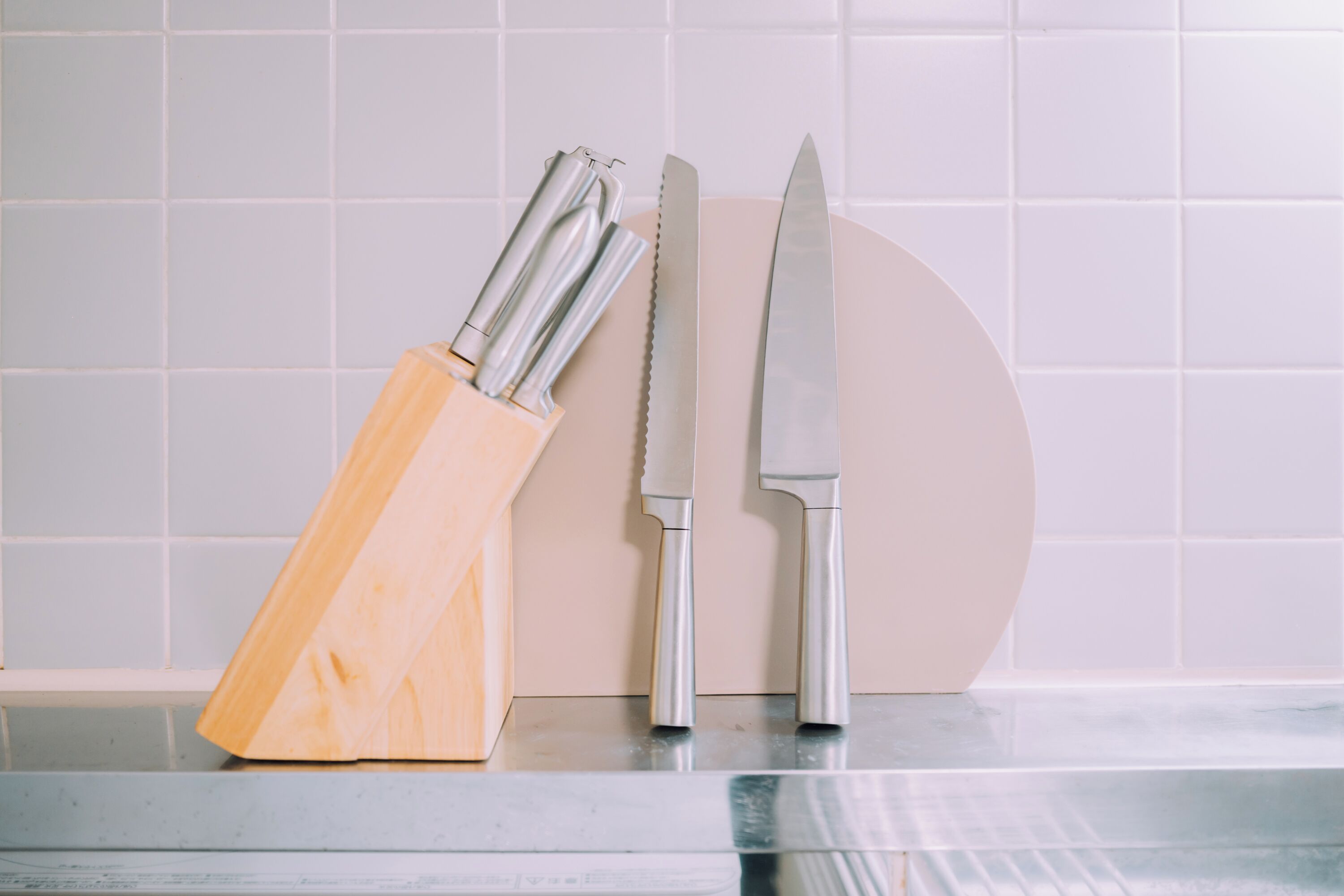 A kitchen counter with a knife block and a knife.
