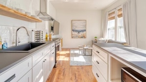 Una cucina moderna con isola centrale, forno integrato e un'ampia finestra con tende.