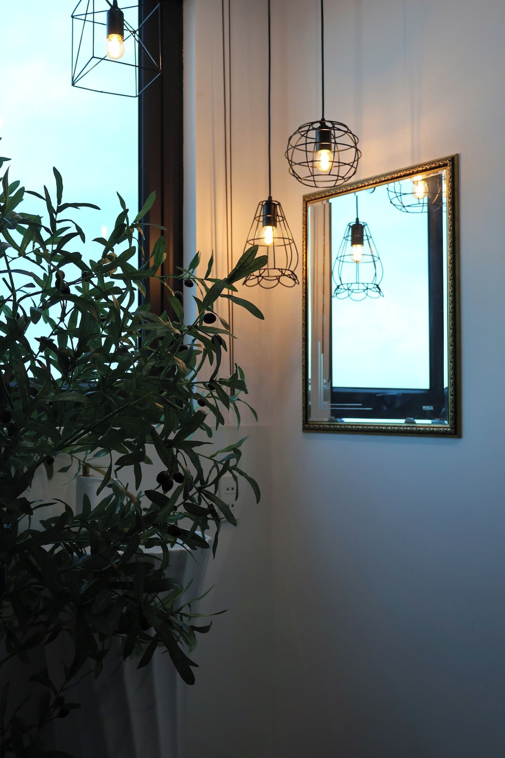 Une pièce dotée d’une grande fenêtre, d’un miroir et de luminaires suspendus.