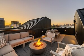 A rooftop terrace with a fire pit, seating area, and a view of the city skyline. - The Chestnut - Brand New Rooftop, Skyline Views (Nashville)