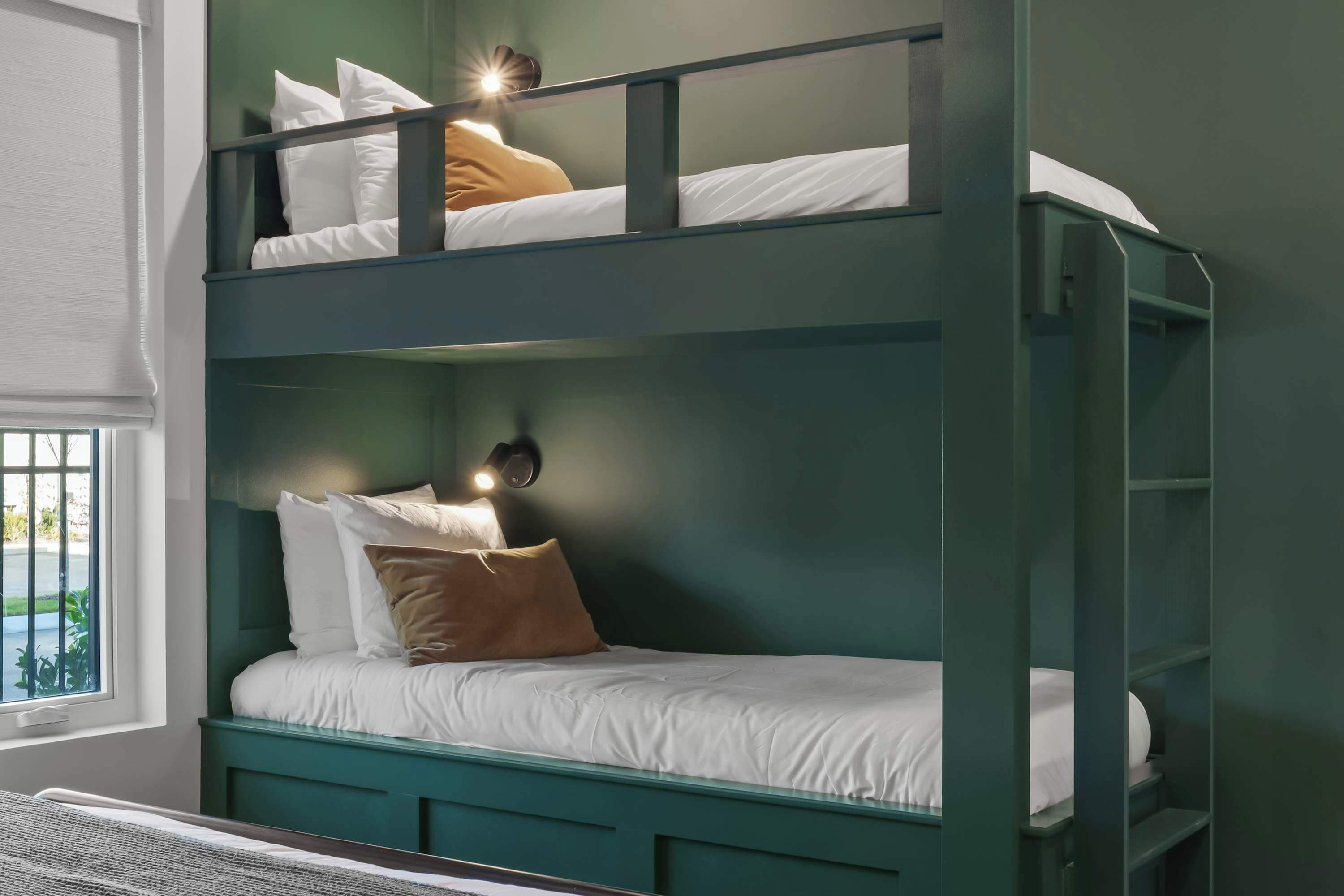 Un lit superposé à deux niveaux, chaque niveau étant équipé d’oreillers et d’une tête de lit.