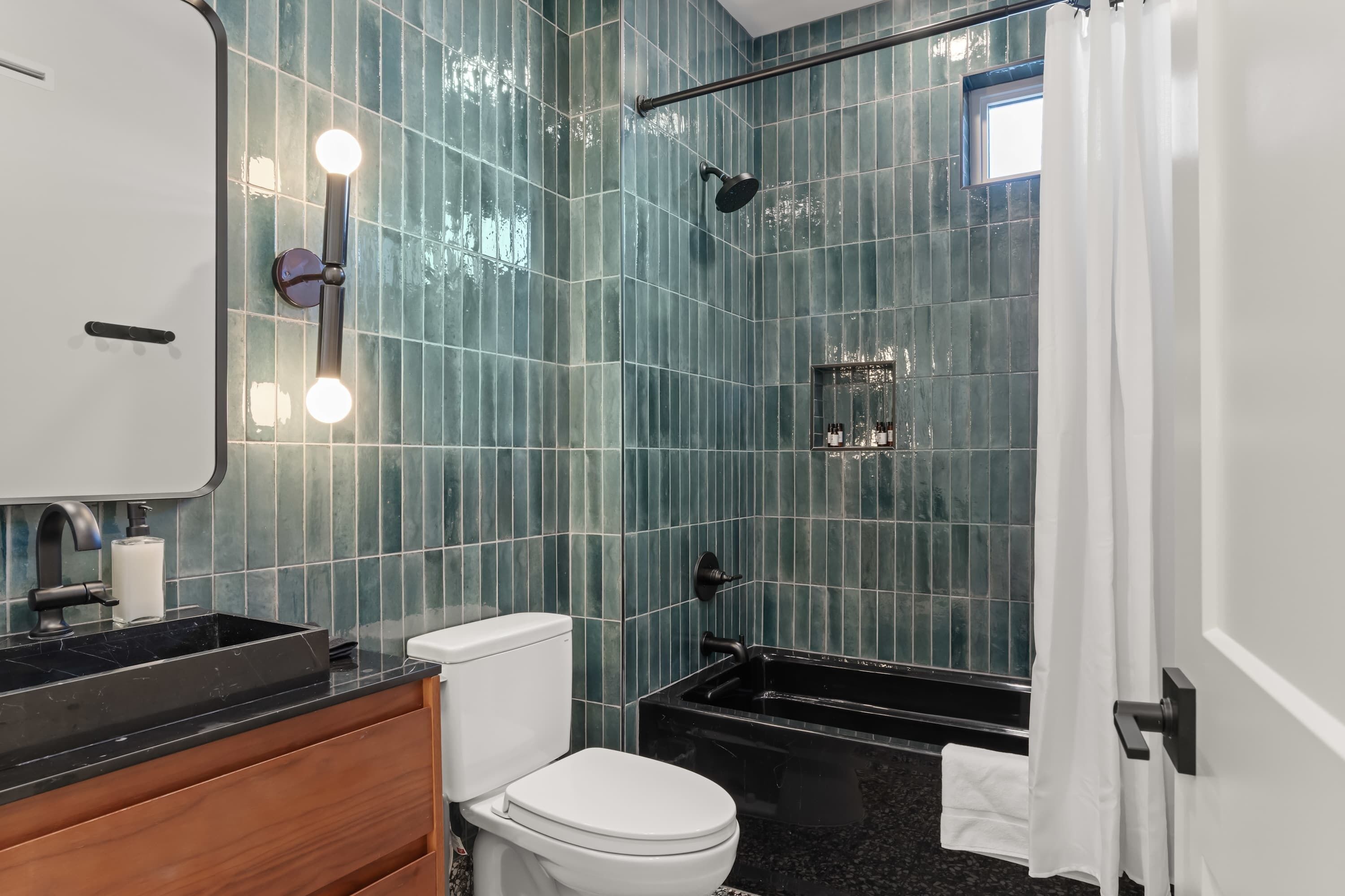 A bathroom with a toilet, sink, and shower area.