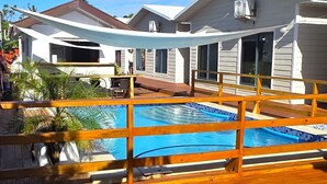 A pool area with a wooden deck and a covered seating area. - Sunset Villas (Korotogo)