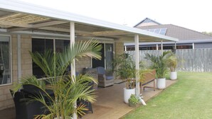 A covered patio area with outdoor furniture and potted plants. - Hideaway on Seattle Dunsborough 5 minute walk to Quindalup Beach & pet friendly. (dunsborugh)