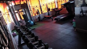 A gym with various exercise equipment including dumbbells, a treadmill, and a bench. - Darrel Paradise Resort (Bungoma)