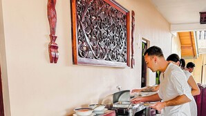 Disposição de buffet com diversos alimentos e um painel decorativo na parede.