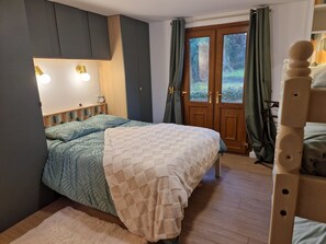 A bedroom with a bed, a nightstand, a mirror, and a wardrobe. - Le Cottage: close to the forest and Baie de Somme. Ideal for families (Machy)
