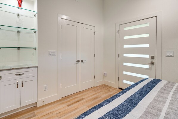 Un dormitorio con cama, armario y estantería de vidrio.