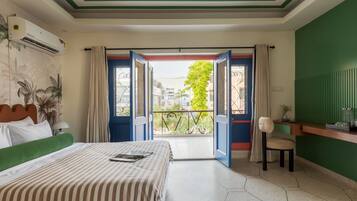 Quarto de hotel com cama, escrivaninha e vista para o exterior.
