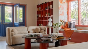 Uma sala de estar com sofá, mesa de centro e estante.