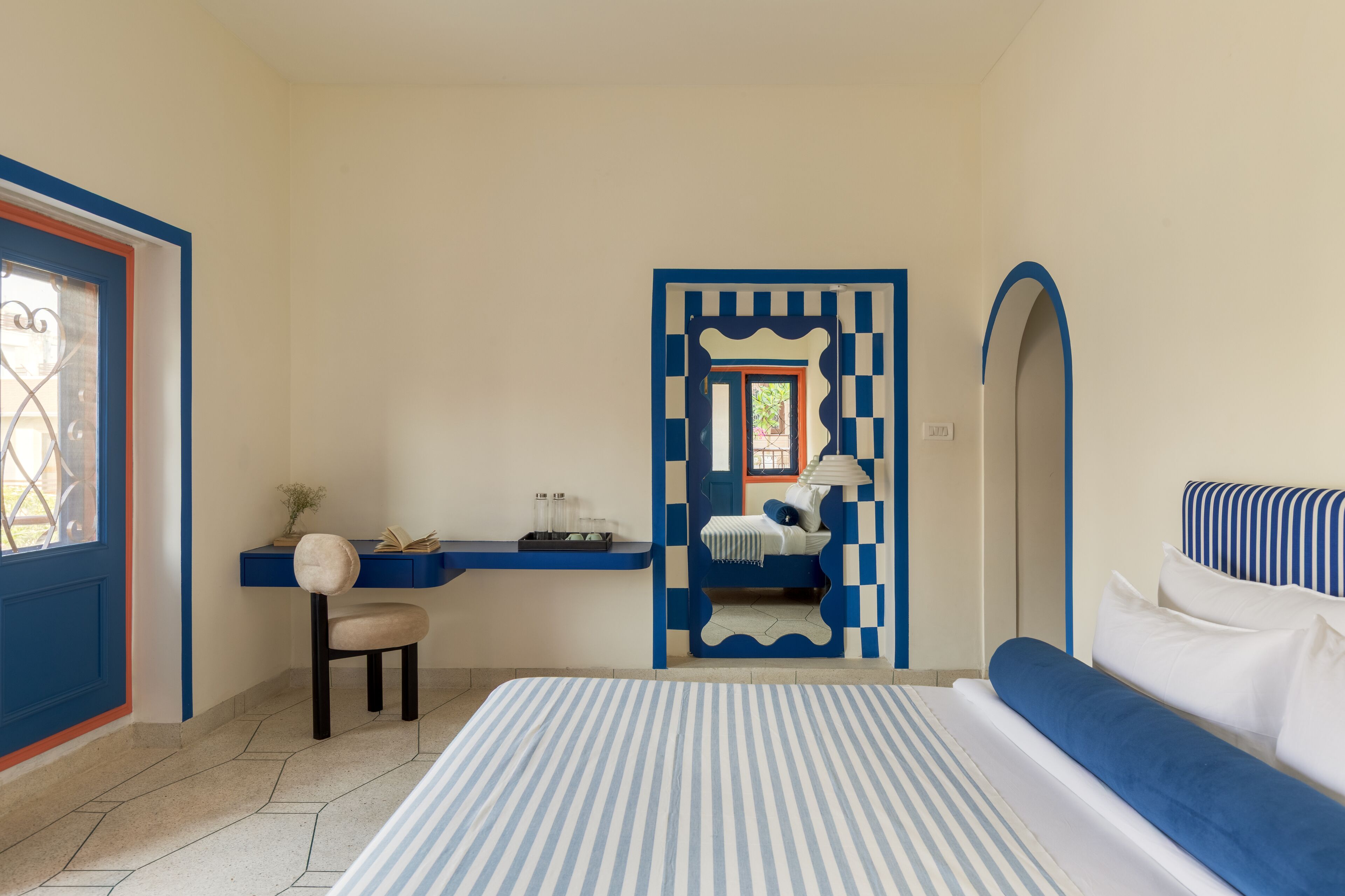 A bedroom with a bed, a desk, and a chair.