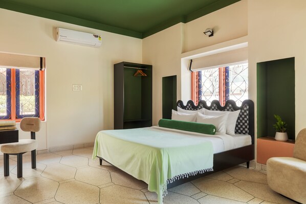 A bedroom with a bed, a chair, a wardrobe, and a potted plant. - Namli Haus A Boutique Luxury Stay Jaipur (Jaipur)