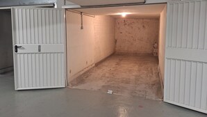 A narrow, dimly lit corridor with a white door on the left and a white wall on the right. - Seaside in Menton.2 rooms with balcony and parking. (Menton)