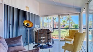 Una sala de estar moderna con un sofá, sillones, una mesa de centro y una lámpara decorativa.