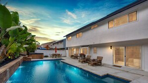 Une maison moderne dotée d’une piscine, de mobilier d’extérieur et d’un espace patio.