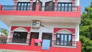 A multi-story building with balconies, windows, and an air conditioning unit. - Shree Shyam Paying Guest House (Varanasi)