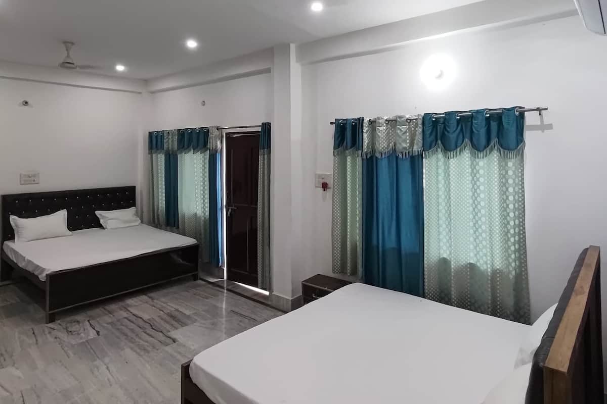 Habitación de hotel con dos camas, ventilador de techo y aire acondicionado.
