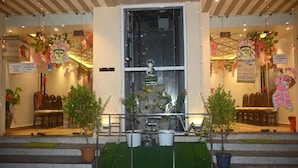 A hotel entrance with a statue, potted plants, and a sign for 'Sea Resort'. - Hotel Sea Wood (Digha)