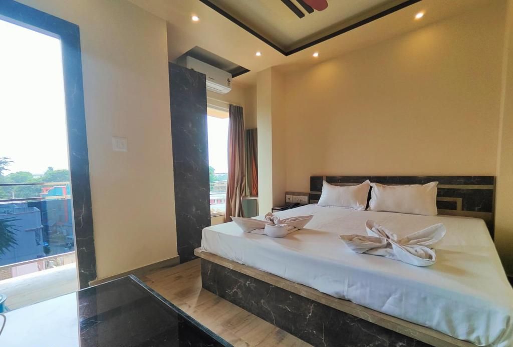 Una camera d'albergo con un letto grande, un tavolino e vista sull'esterno.