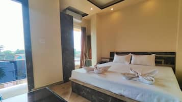 Una camera d'albergo con un letto grande, un tavolino e vista sull'esterno.
