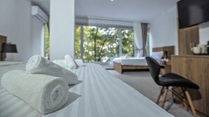 A modern hotel room with a large bed, a desk, and a chair. - Hotel Riverside (Skopje)