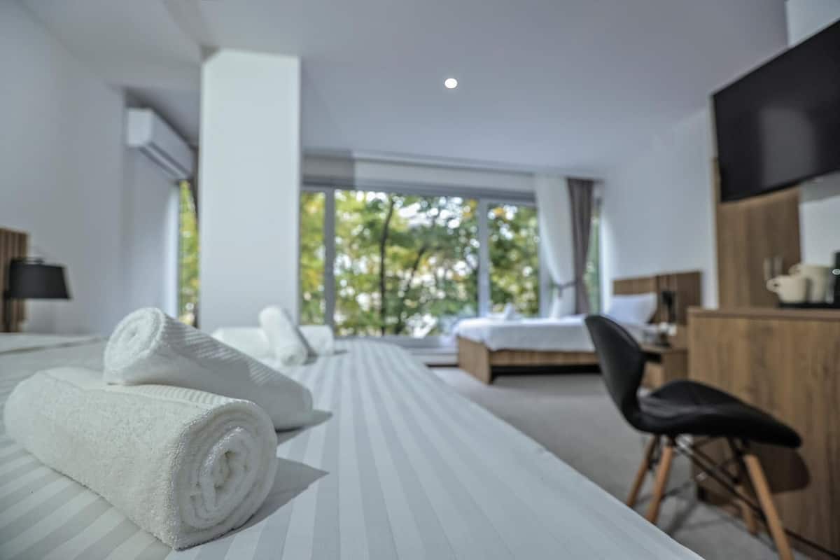 Ett modernt hotellrum med en stor säng, ett skrivbord och en stol.