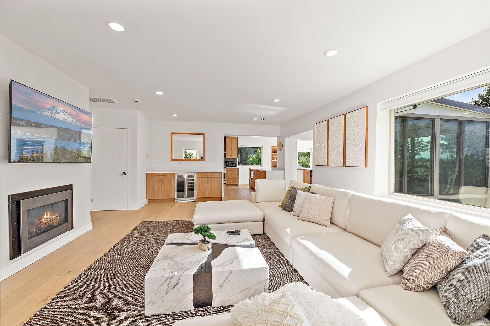 A modern living room with a fireplace, a large TV, and a sofa.