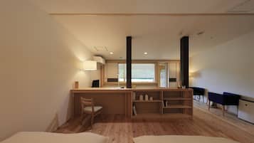 A modern room with a wooden desk, a chair, a bed, and a small table with a lamp.