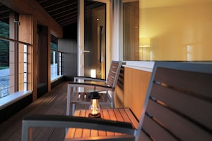 Um deck de madeira com bancos e uma mesa, com vista para um corpo d'água.