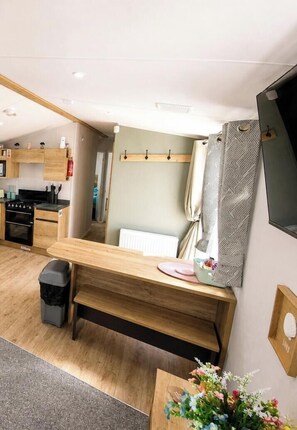 A compact RV kitchen with a refrigerator, microwave, and stove.