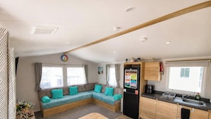 A compact living space with a sofa, a kitchen area, and a window.