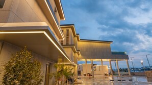A modern hotel with a spacious outdoor area, multiple levels, and a view of the city skyline. - Ocean Bliss (Ulsan)