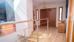 A staircase with metal railings leading to a wooden door. - Golf-view villa with pool (Chiclana de la Frontera)