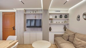 A modern living room with a TV, sofa, and coffee table. - Sublime AC Apartment Eiffel Tower Champs de Mars (Paris)