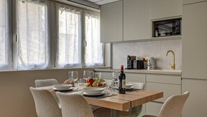 A modern kitchen with a dining area. - Sublime AC Apartment Eiffel Tower Champs de Mars (Paris)