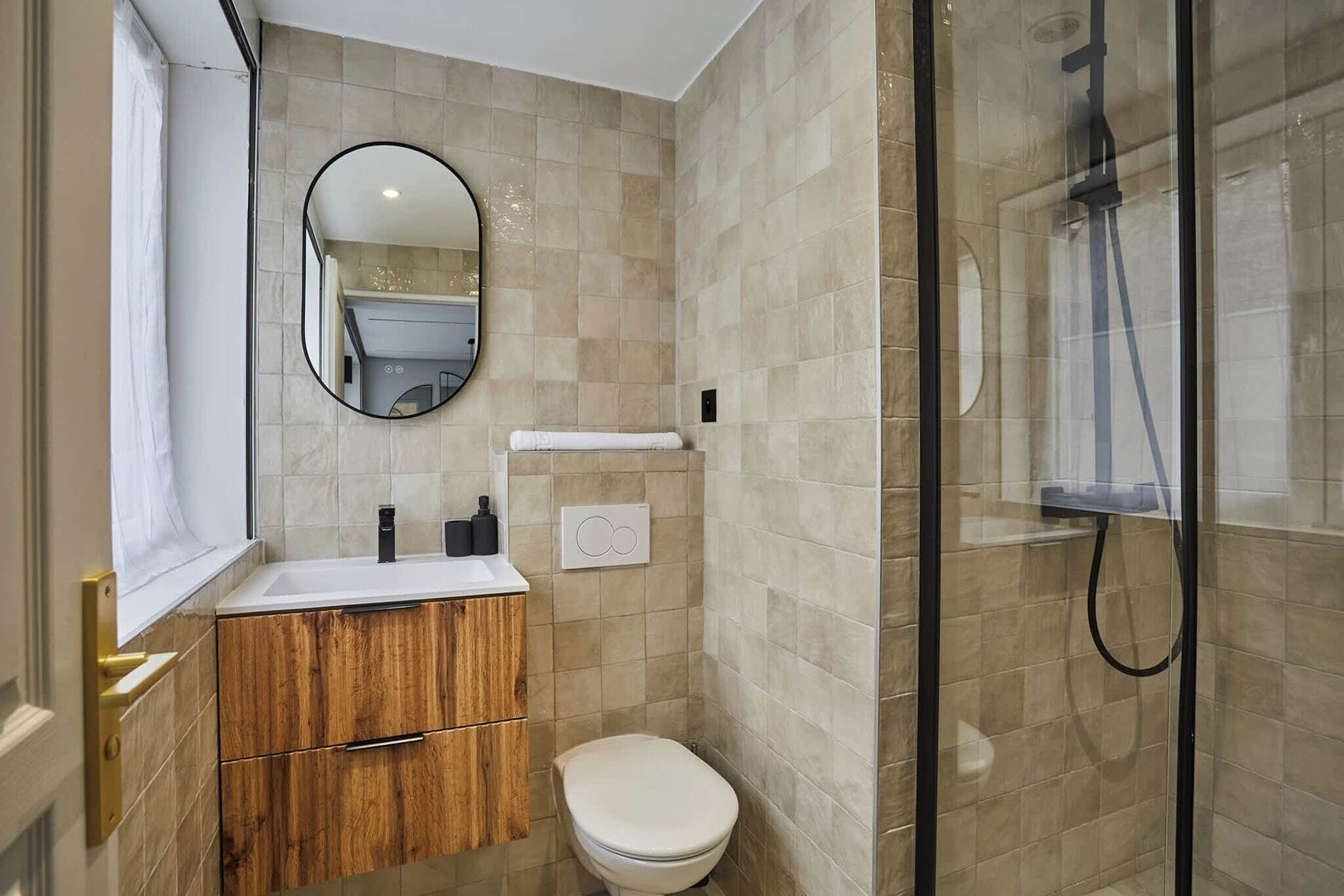 Un bagno compatto con servizi igienici, lavandino e doccia.