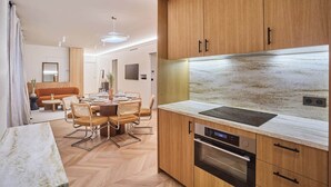 Eine moderne Küche mit Holzausstattung, einer Marmorarbeitsplatte und eingebauten Geräten.