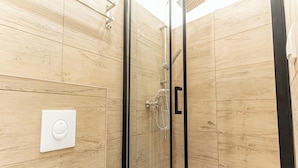 A modern shower with a glass enclosure, wooden walls, and a control panel. - Cozy 1BR Apartment in Prime Location (Vienna)