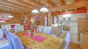 Un interior de madera con comedor, cocina y asientos.