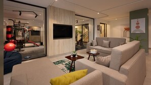 Un salon moderne avec un canapé, une table basse et un téléviseur fixé au mur.