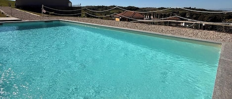 A clear blue pool with a modern building in the background.