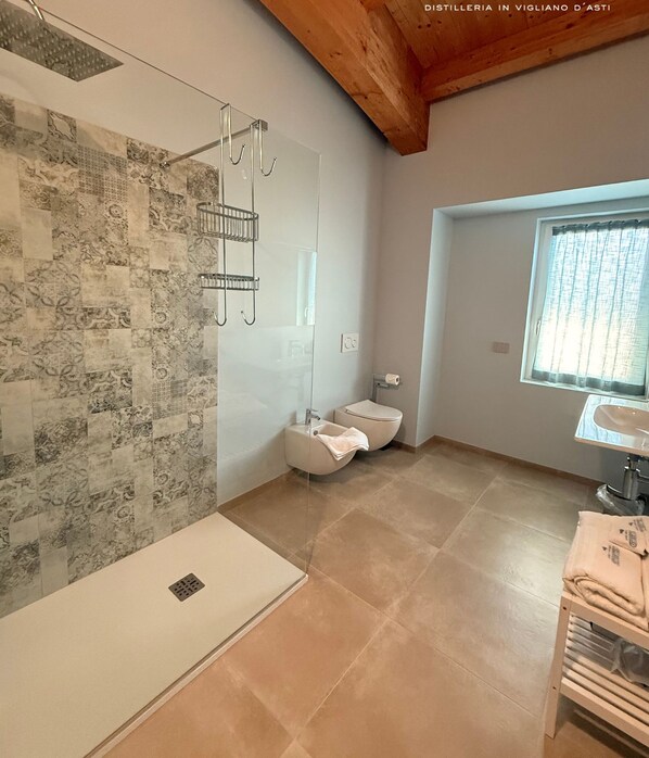 Un baño moderno con ducha, inodoro y lavamanos.