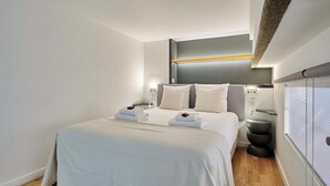 Ein modernes Hotelzimmer mit einem großen Bett, Nachttischen und einer Wandleuchte.